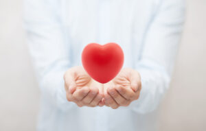 Bilde viser en person som holder hendene som en boller hvor det svever et hjerte over.