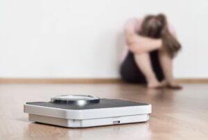 Trist jente ved vekt Foto: Shutterstock