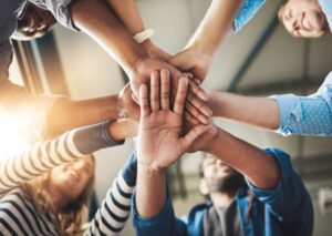 Gruppe mennesker som har hendene sammen i en ring Foto. Shutterstock