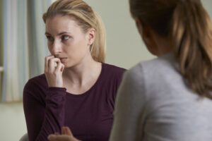 Ung kvinne i samtale med rådgiver. Foto Colourbox