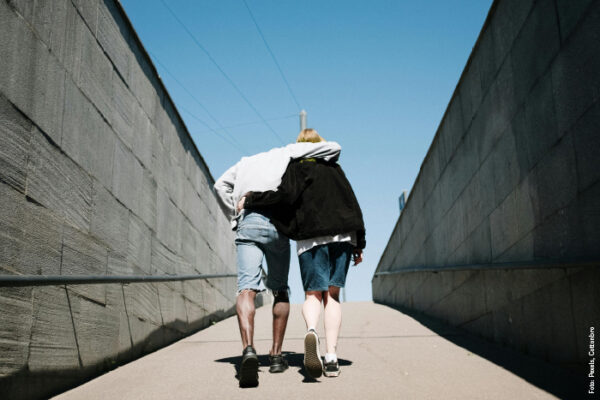 Fotografi av par gående opp en bakke, holder rundt hverandre samtidig som de går