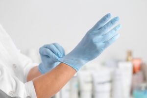 Helsepersonell tar på blå hansker