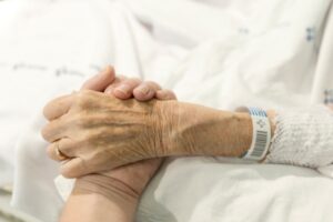En eldre pasient blir holdt i hånden