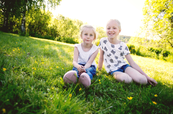Fotografi av to små barn i en park om sommeren